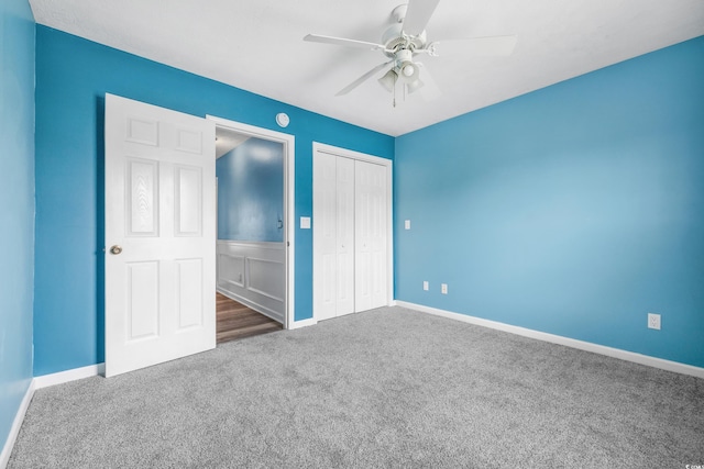 unfurnished bedroom with a closet, ceiling fan, and dark colored carpet