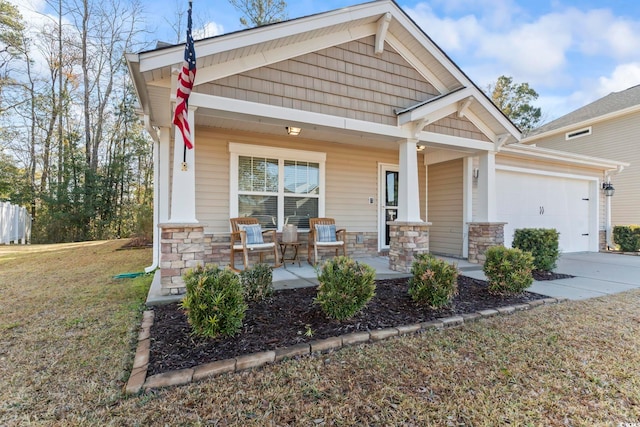 craftsman-style home featuring a garage, covered porch, and a front lawn