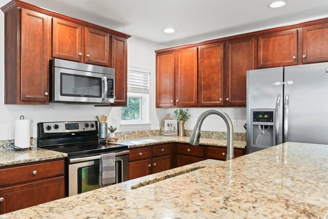 kitchen featuring light stone countertops and appliances with stainless steel finishes