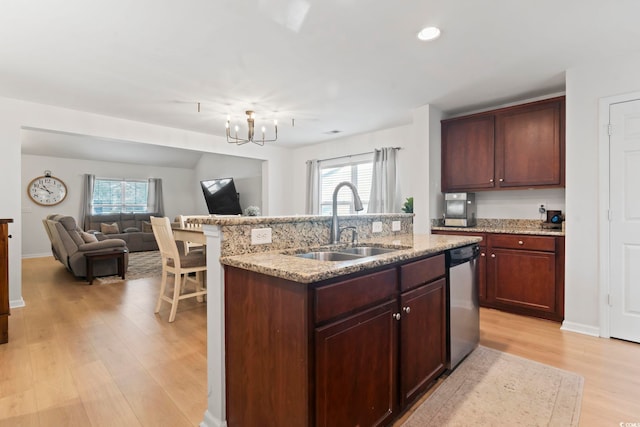 kitchen with sink, a kitchen island with sink, a healthy amount of sunlight, stainless steel dishwasher, and light wood-type flooring