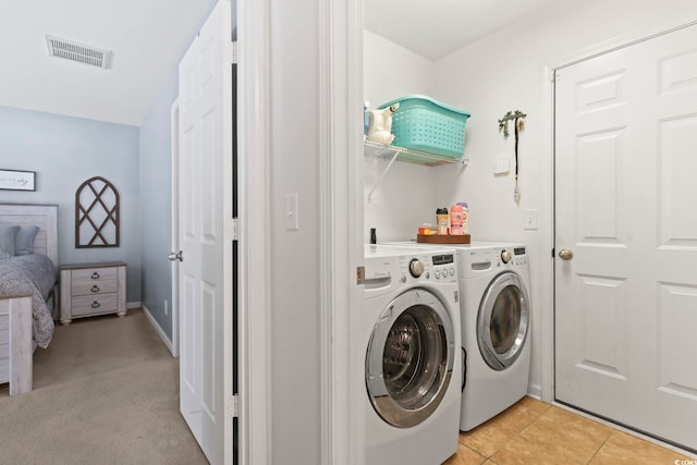 laundry room featuring light tile patterned floors and washing machine and clothes dryer