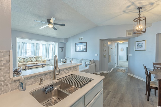 kitchen with visible vents, open floor plan, dark wood-style flooring, a sink, and backsplash