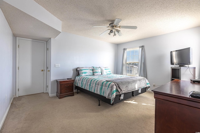 bedroom with ceiling fan, a textured ceiling, baseboards, and light colored carpet