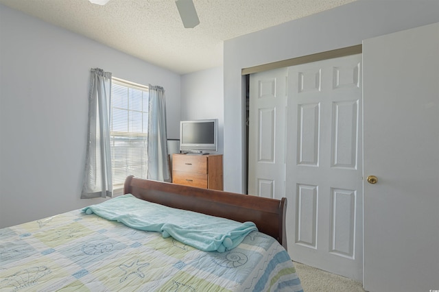 bedroom with a ceiling fan, a closet, carpet flooring, and a textured ceiling