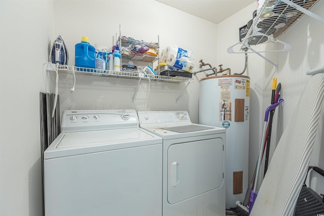 laundry area with laundry area, water heater, a textured ceiling, and separate washer and dryer