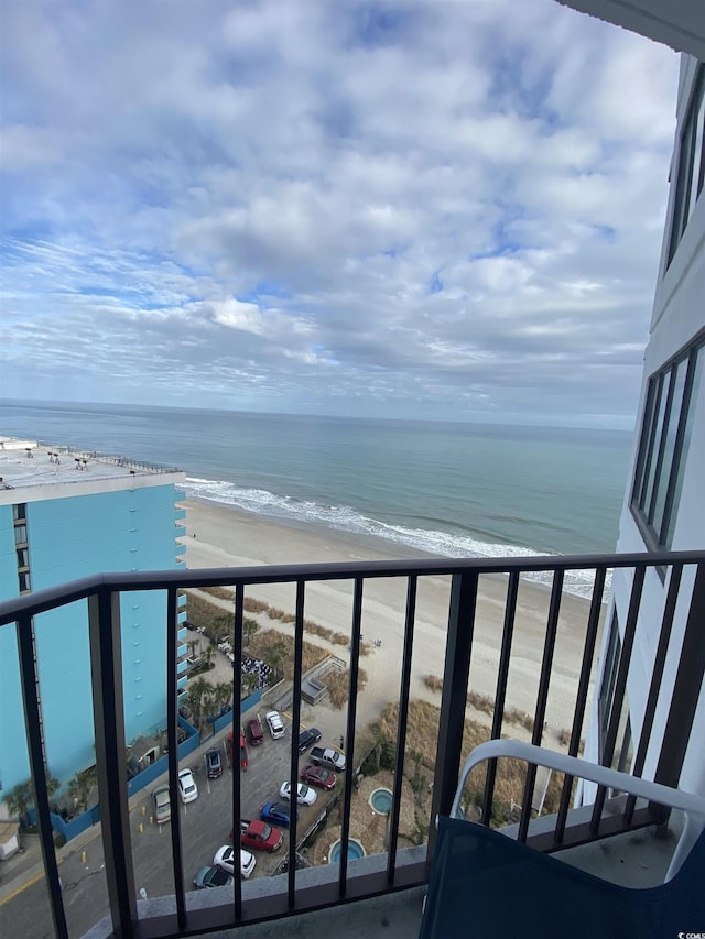 balcony featuring a view of the beach and a water view