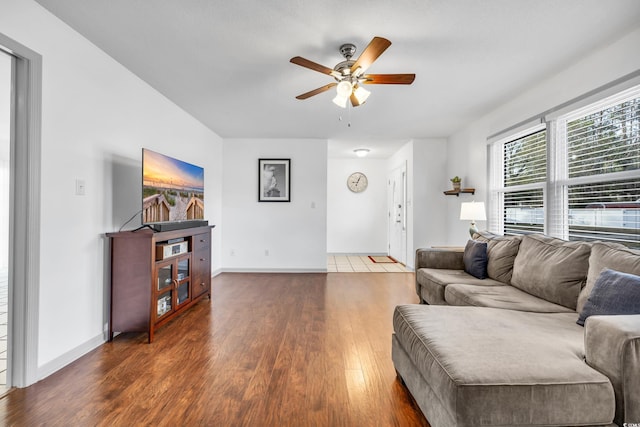 living room featuring dark wood-type flooring and ceiling fan