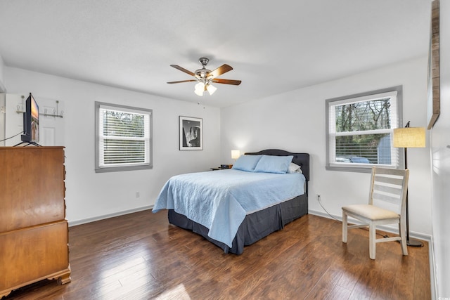 bedroom featuring multiple windows, dark wood-type flooring, and ceiling fan