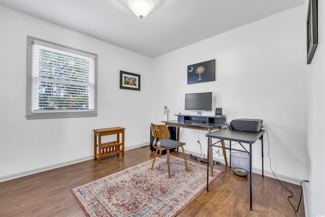 office area with dark wood-type flooring and a baseboard heating unit