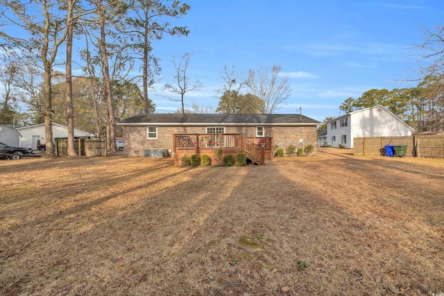 single story home with a wooden deck and a front yard