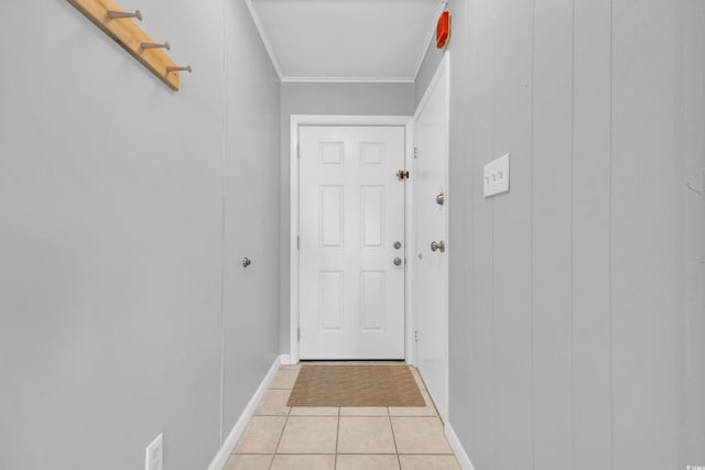 entryway with light tile patterned flooring and ornamental molding