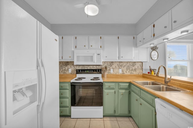 kitchen featuring light tile patterned flooring, sink, green cabinets, white appliances, and decorative backsplash