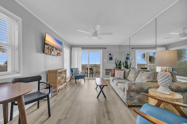 living room featuring ornamental molding, ceiling fan, and light wood-type flooring