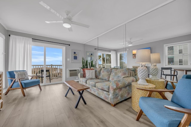 living room with a wall mounted AC, ceiling fan, and light hardwood / wood-style flooring