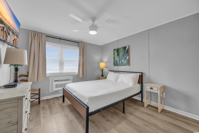 bedroom with ceiling fan, light hardwood / wood-style floors, and a wall unit AC