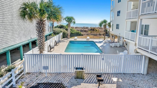 view of swimming pool featuring a water view and a patio area