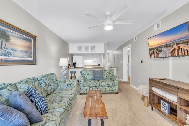 living room featuring ornamental molding, light carpet, and ceiling fan