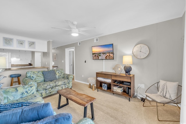 living room featuring crown molding, light carpet, and ceiling fan