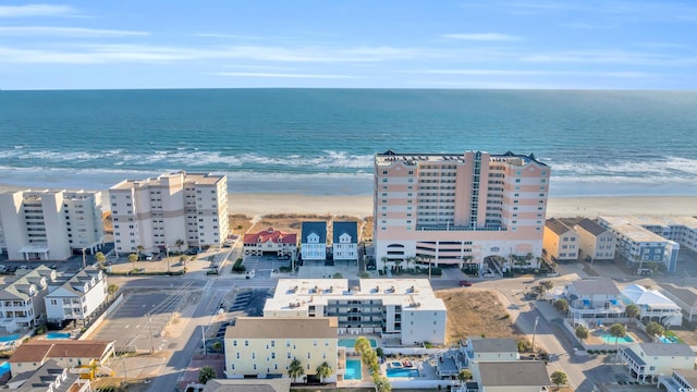 birds eye view of property with a water view and a beach view