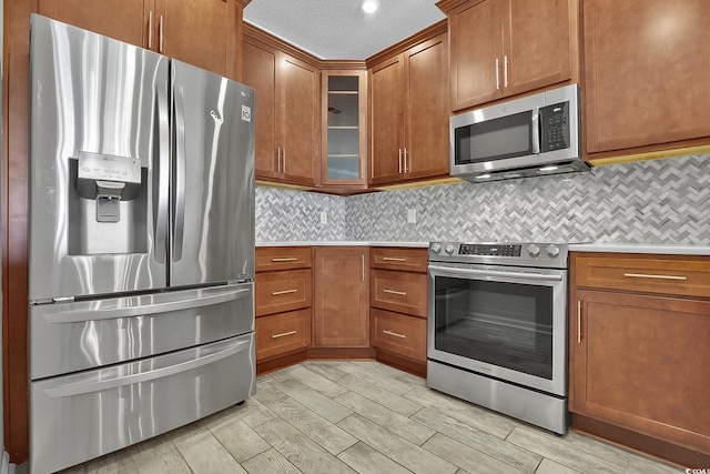 4200 Coquina Harbour Dr Unit H3, Little River, SC 29566 - kitchen with appliances with stainless steel finishes, light countertops, brown cabinetry, wood tiled floors, and a textured ceiling