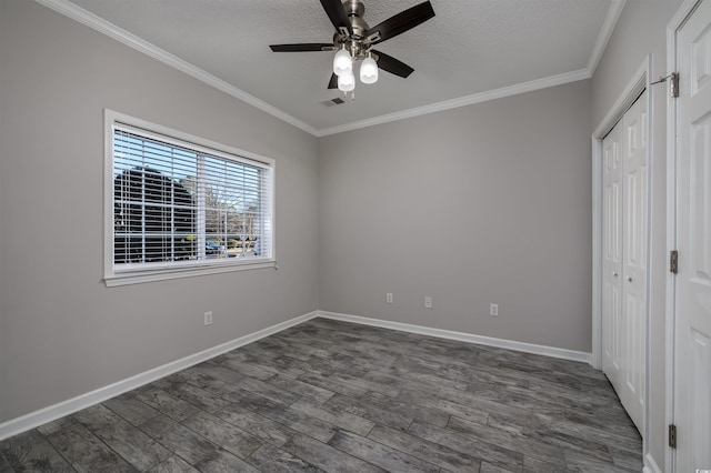 unfurnished bedroom with crown molding, dark wood-type flooring, a textured ceiling, and a closet