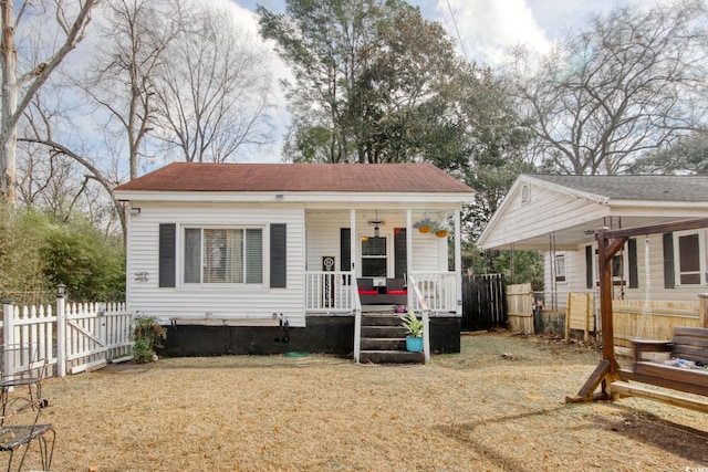 bungalow-style home featuring a front yard and covered porch