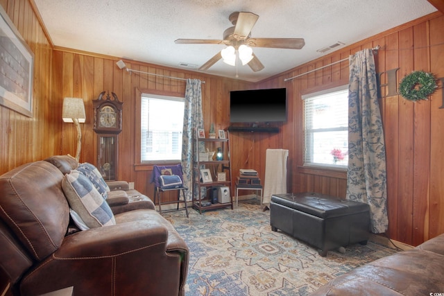 living room featuring crown molding, carpet floors, a textured ceiling, and ceiling fan