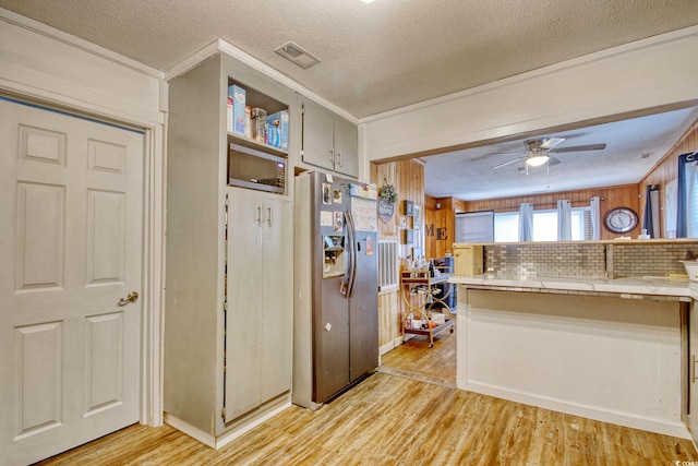 kitchen featuring tasteful backsplash, light wood-type flooring, ceiling fan, stainless steel refrigerator with ice dispenser, and a textured ceiling