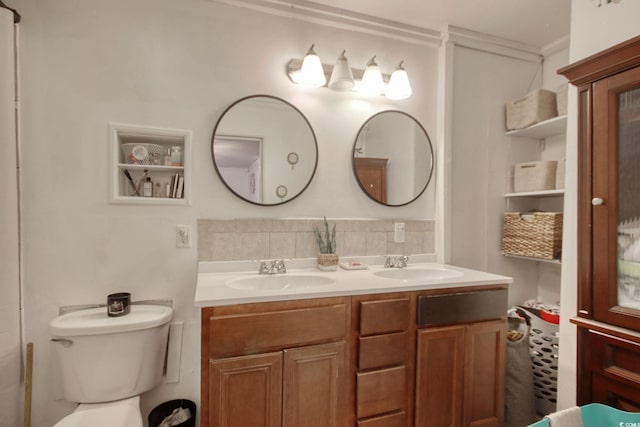 bathroom featuring vanity, toilet, crown molding, and decorative backsplash