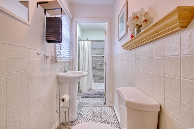 bathroom featuring tile walls, curtained shower, and toilet