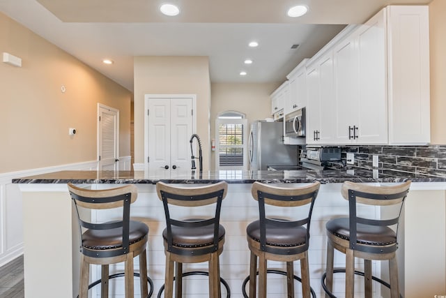 4609 Lightkeepers Way Unit 11J, Little River, SC 29566 - kitchen with dark stone counters, recessed lighting, white cabinets, and appliances with stainless steel finishes