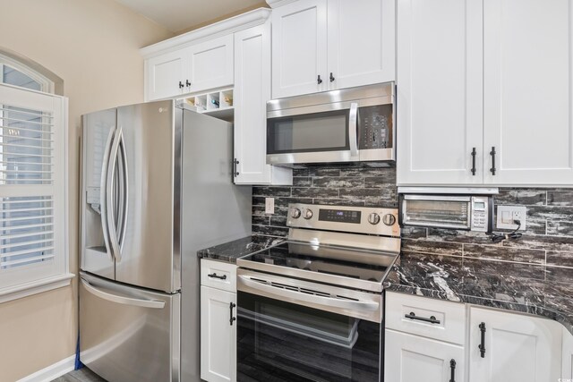 4609 Lightkeepers Way Unit 11J, Little River, SC 29566 - kitchen with dark stone counters, white cabinetry, stainless steel appliances, and backsplash