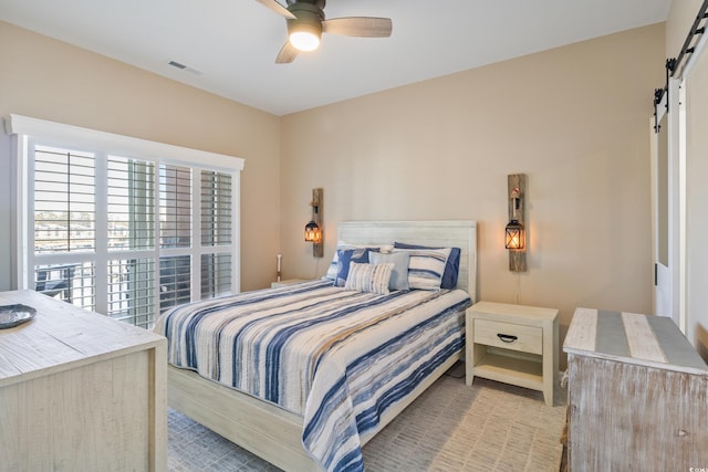 4609 Lightkeepers Way Unit 11J, Little River, SC 29566 - bedroom featuring a ceiling fan, visible vents, and a barn door