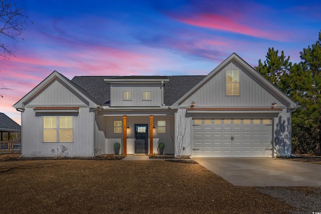 view of front of property featuring a garage, concrete driveway, and a shingled roof