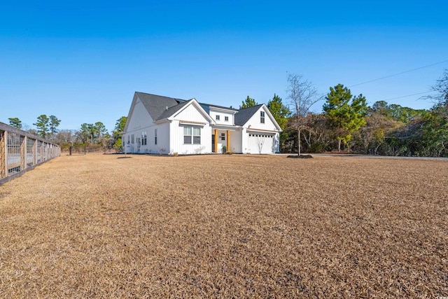 modern inspired farmhouse with fence and a front lawn