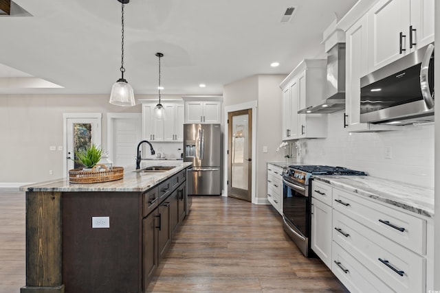 kitchen featuring white cabinets, a kitchen island with sink, stainless steel appliances, and a sink