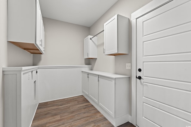 laundry room with dark wood-style flooring and wainscoting