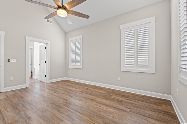 spare room with light wood-style floors, vaulted ceiling, ceiling fan, and baseboards