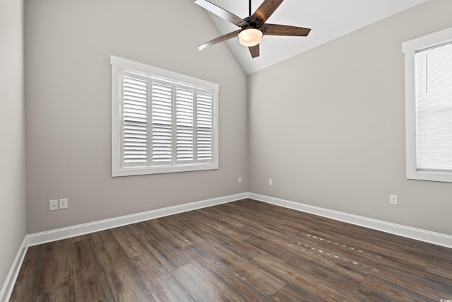 spare room featuring baseboards, vaulted ceiling, and dark wood-style flooring