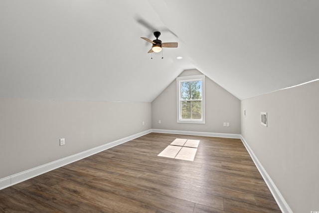 bonus room featuring dark wood-style floors, visible vents, vaulted ceiling, ceiling fan, and baseboards