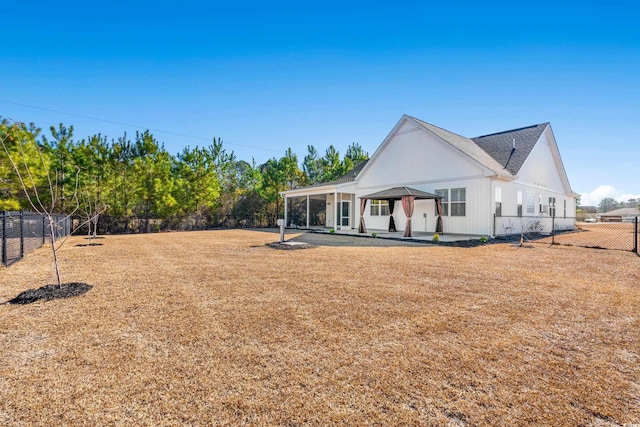 rear view of property featuring a gazebo, a patio, and a fenced backyard