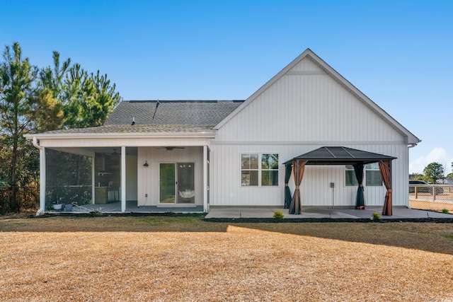 rear view of property with a gazebo, roof with shingles, a patio area, and fence