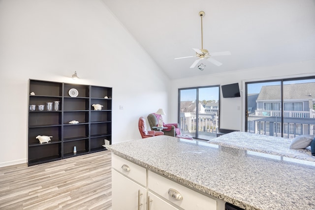 kitchen featuring ceiling fan, white cabinets, light stone counters, and light hardwood / wood-style flooring