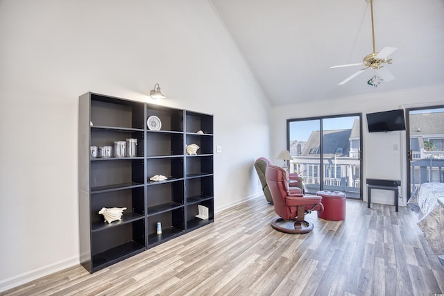 living area featuring ceiling fan, wood-type flooring, and high vaulted ceiling