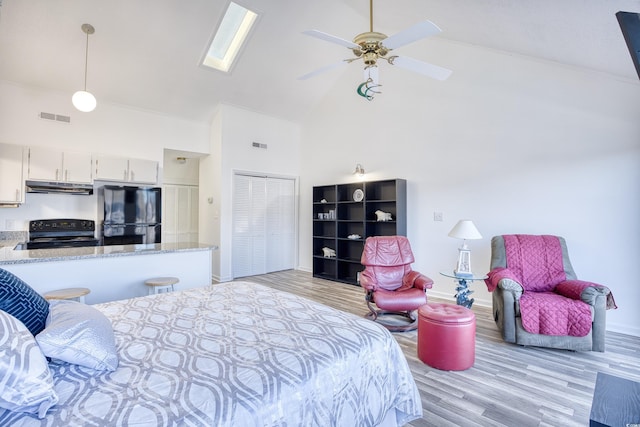 bedroom with high vaulted ceiling, light hardwood / wood-style flooring, ceiling fan, black fridge, and a closet