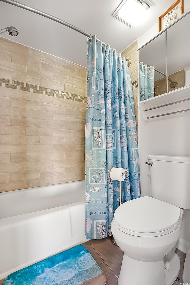 bathroom with shower / tub combo with curtain and toilet