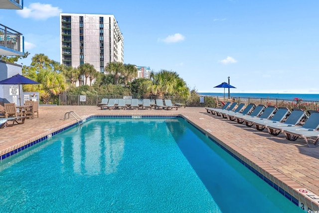 view of swimming pool with a water view and a patio area