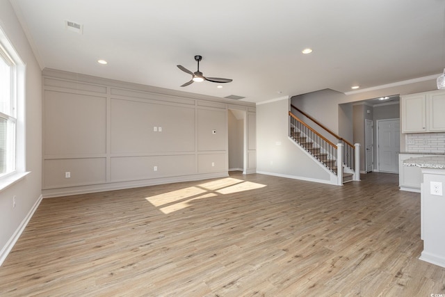 unfurnished living room with crown molding, ceiling fan, and light hardwood / wood-style floors