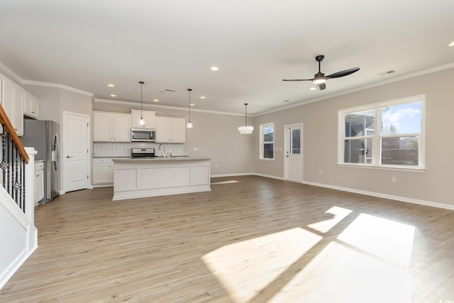 unfurnished living room featuring sink, crown molding, light hardwood / wood-style flooring, and ceiling fan with notable chandelier