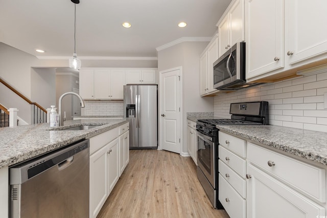 kitchen with white cabinetry, sink, stainless steel appliances, and light stone countertops